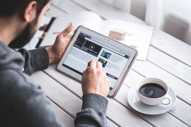 man holding a tablet sitting at table