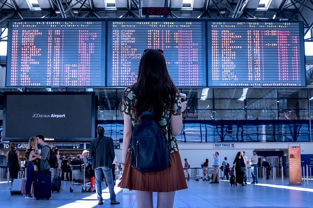 woman looking at times on sign at airport