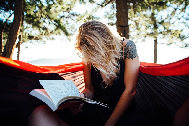 woman reading a book outside on a sunny day