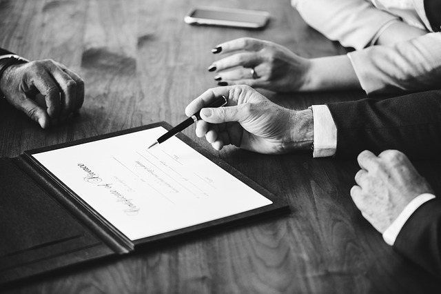 people working on a legal document only showing hands and document