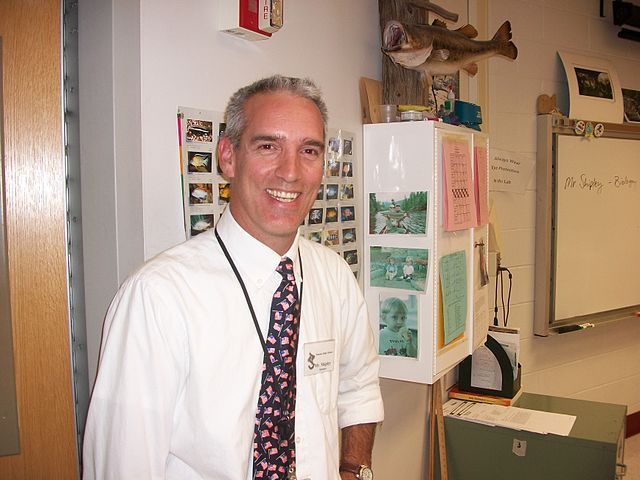 Male Professor with EdD degree standing in the hallway