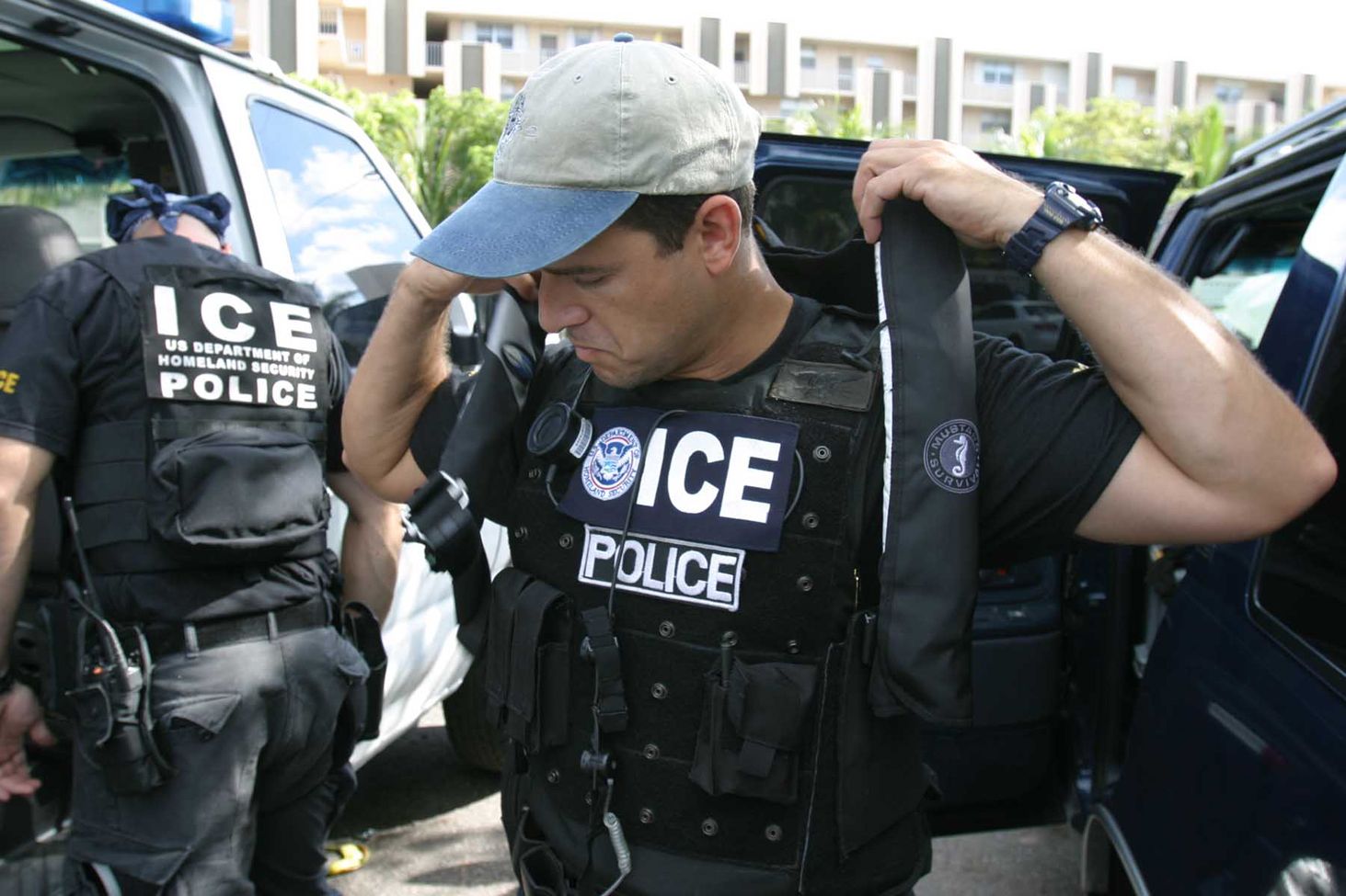 police officer putting on vest near other police officerslaw enforcement