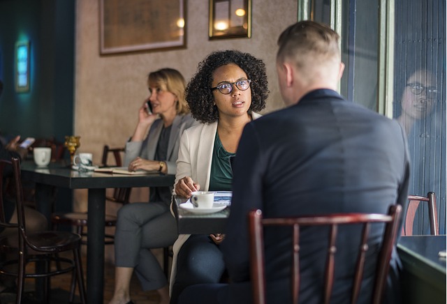 African American parole officer talking to man at a table